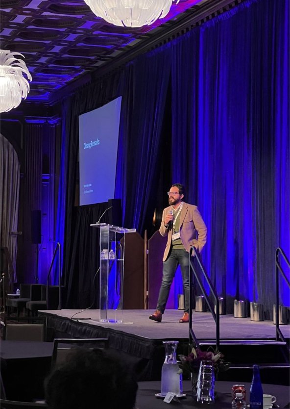 Speaker on stage in front of a Teleport-branded screen